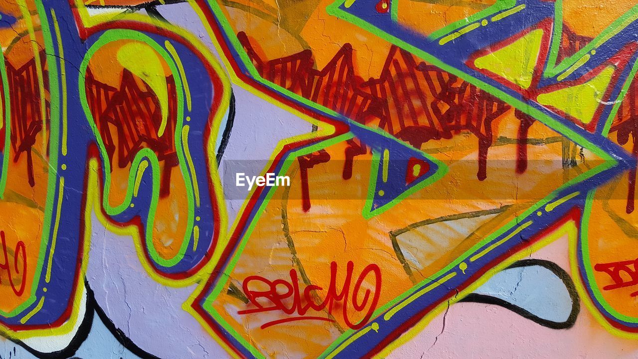 FULL FRAME SHOT OF GRAFFITI ON TEXT