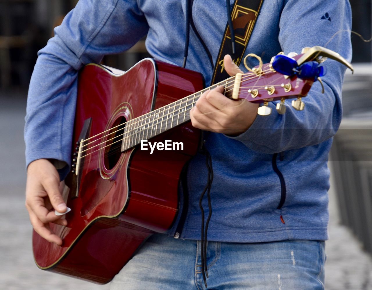 Midsection of man playing guitar