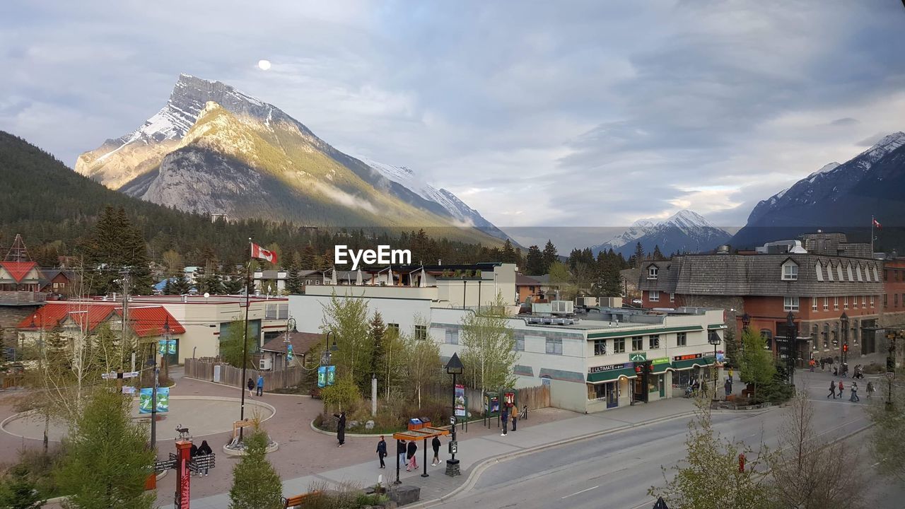 PANORAMIC VIEW OF BUILDINGS AND MOUNTAINS AGAINST SKY IN CITY