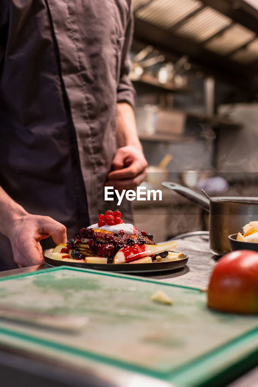 Midsection of man preparing food in kitchen