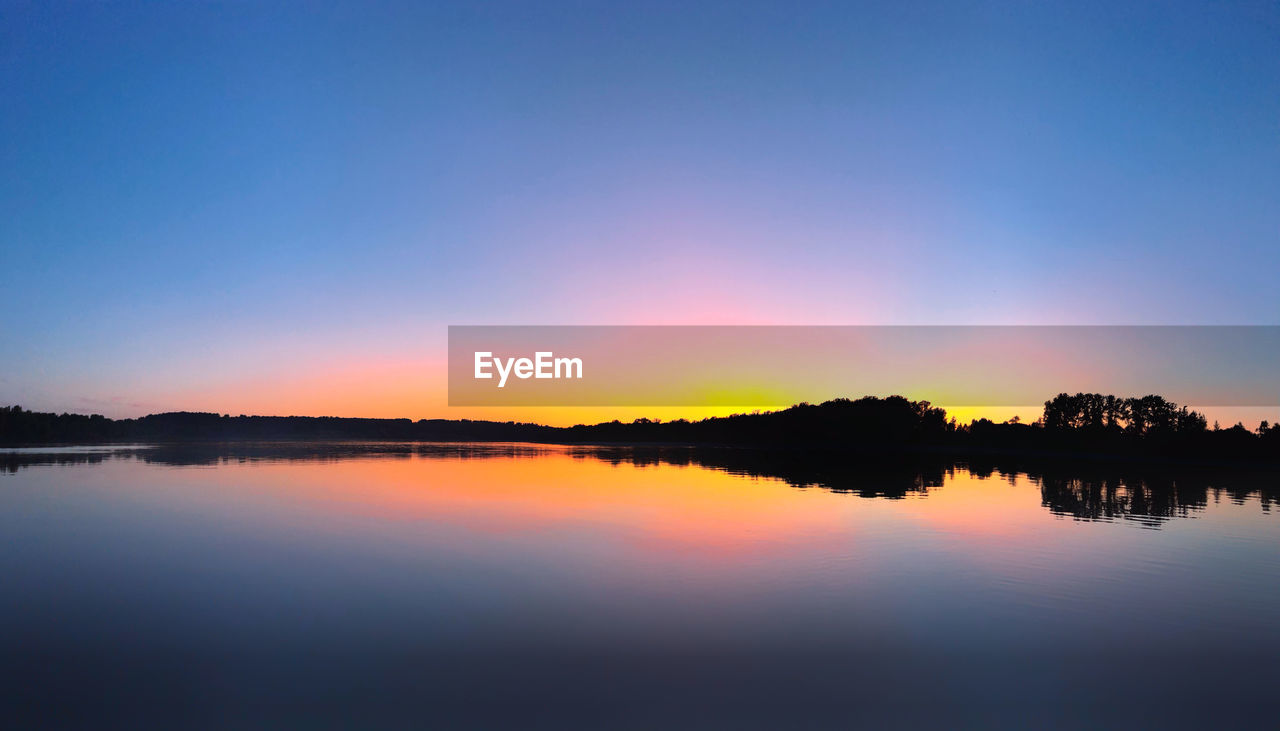 Scenic view of lake against sky during sunset