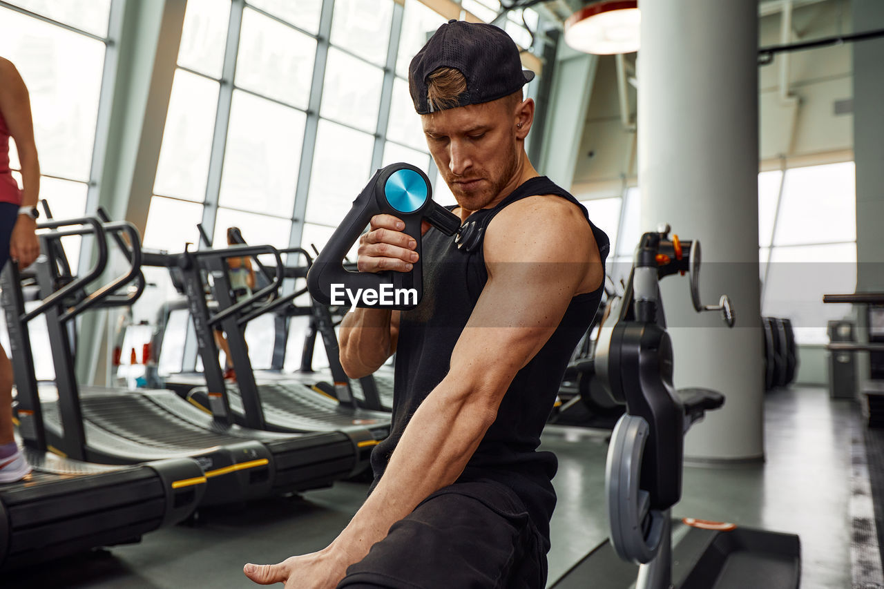 side view of man exercising at gym