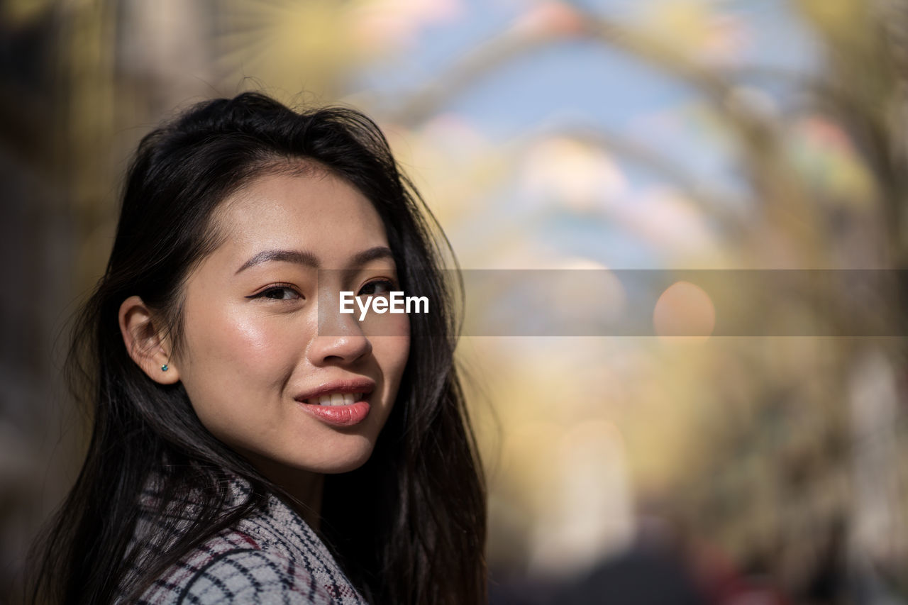 Happy ethnic young woman on street in downtown