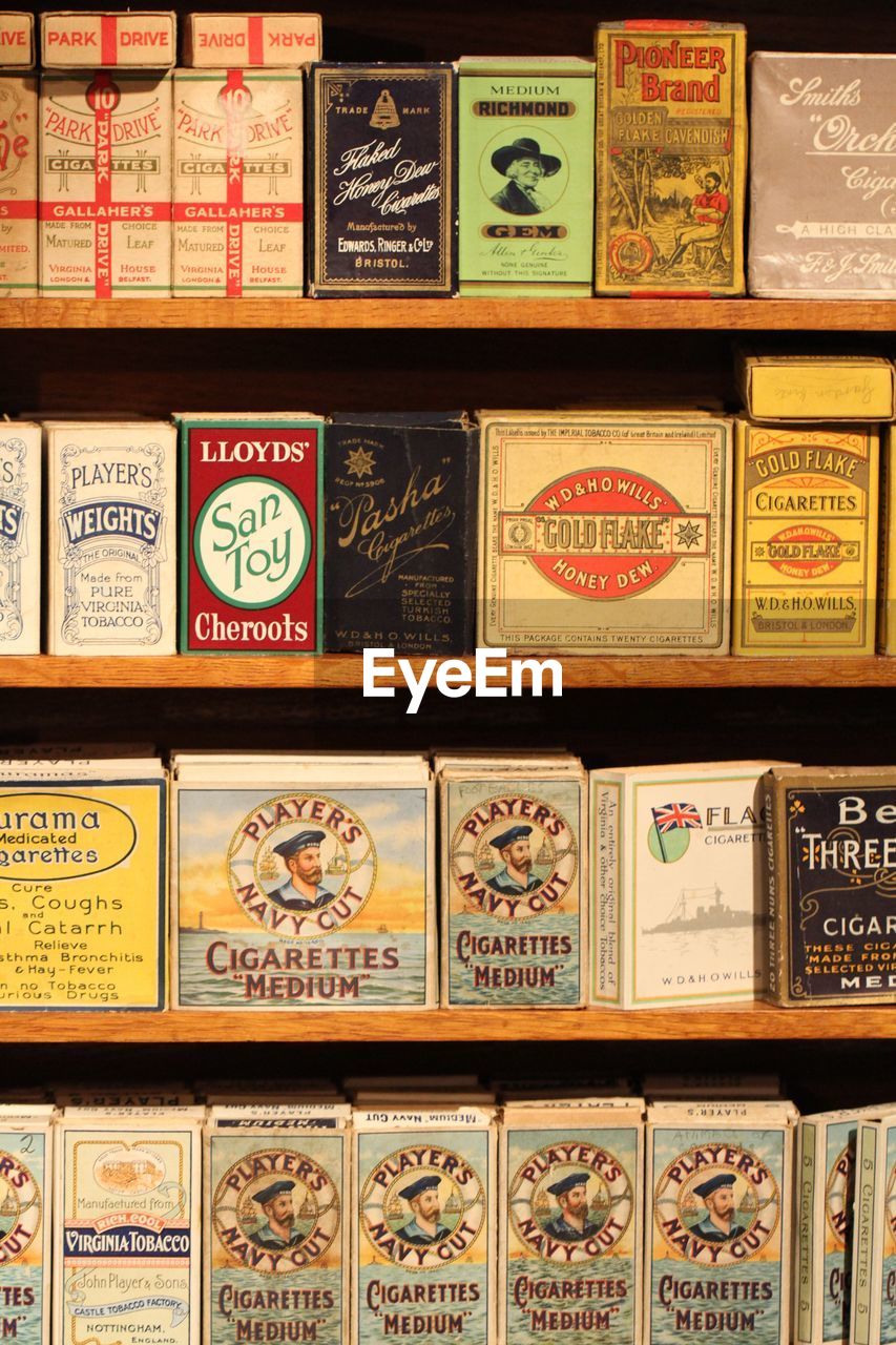 Close-up of cigarette packs on shelf at store