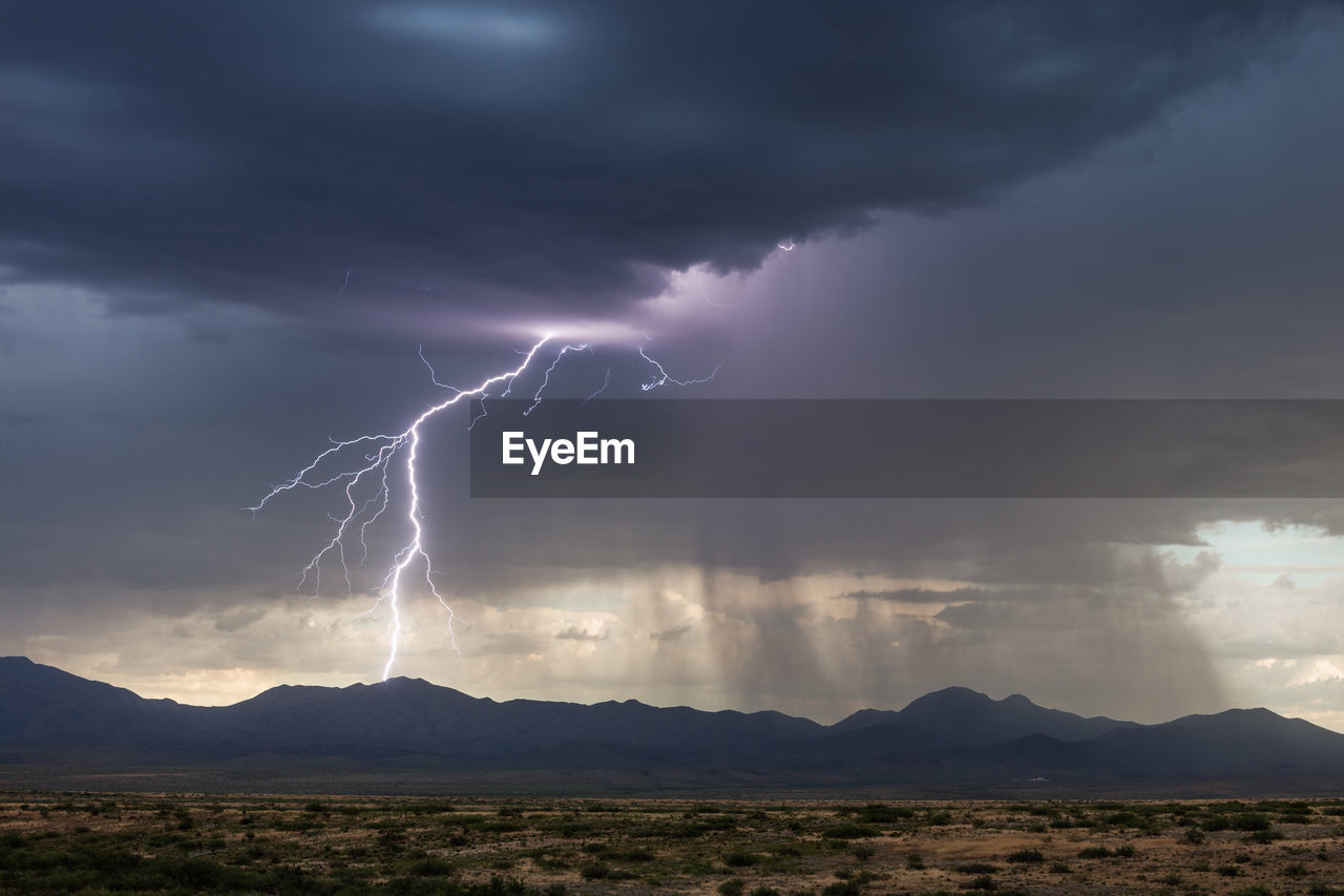 Lightning strikes the chiricahua mountains during a monsoon storm near willcox, arizona.