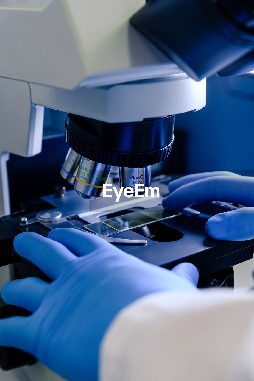 Cropped hands of scientist holding microscope slide