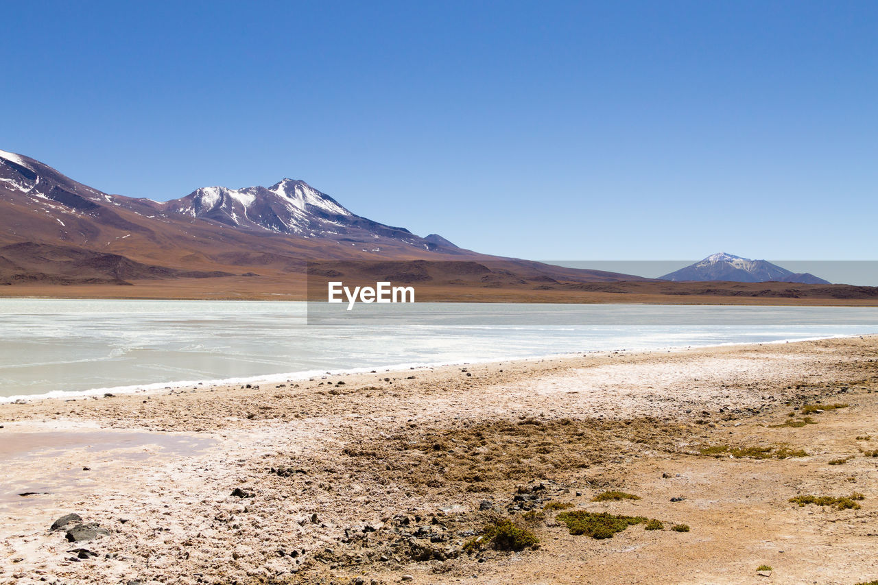 SCENIC VIEW OF SNOWCAPPED MOUNTAINS AGAINST BLUE SKY