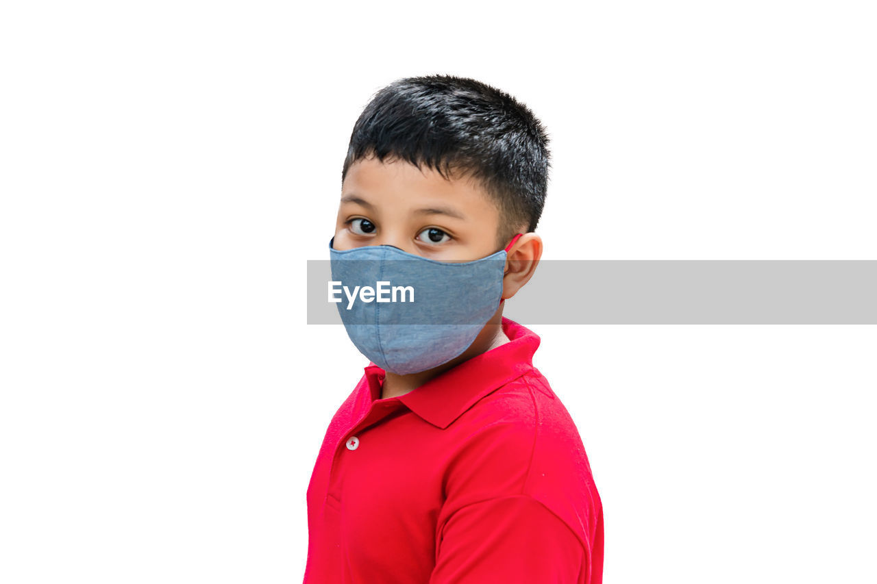 PORTRAIT OF BOY STANDING ON WHITE BACKGROUND