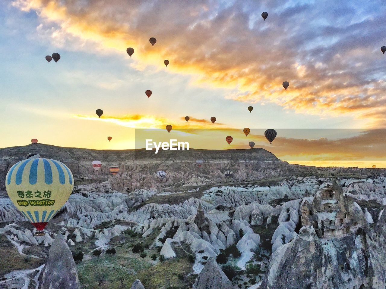 HOT AIR BALLOONS FLYING OVER LANDSCAPE