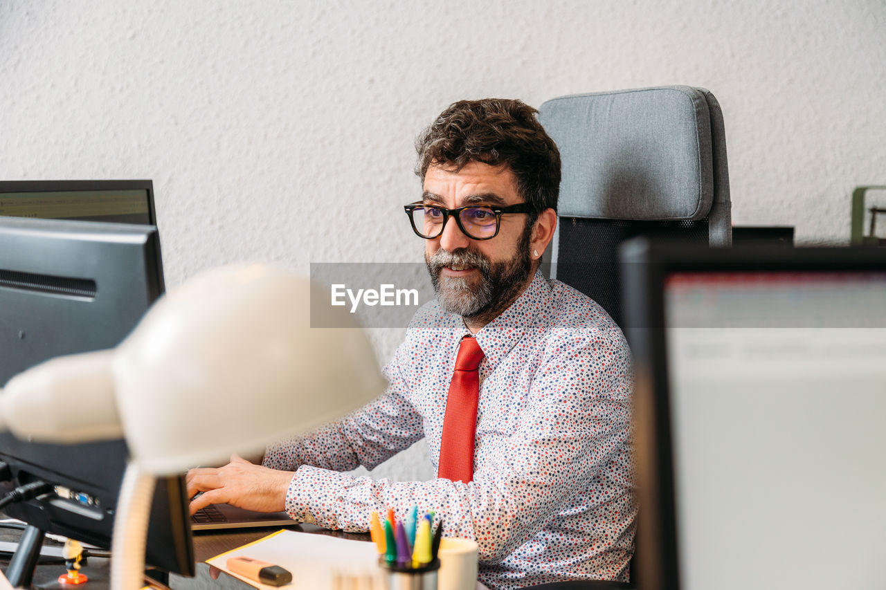 Middle-aged businessman with beard and glasses meeting for video conference