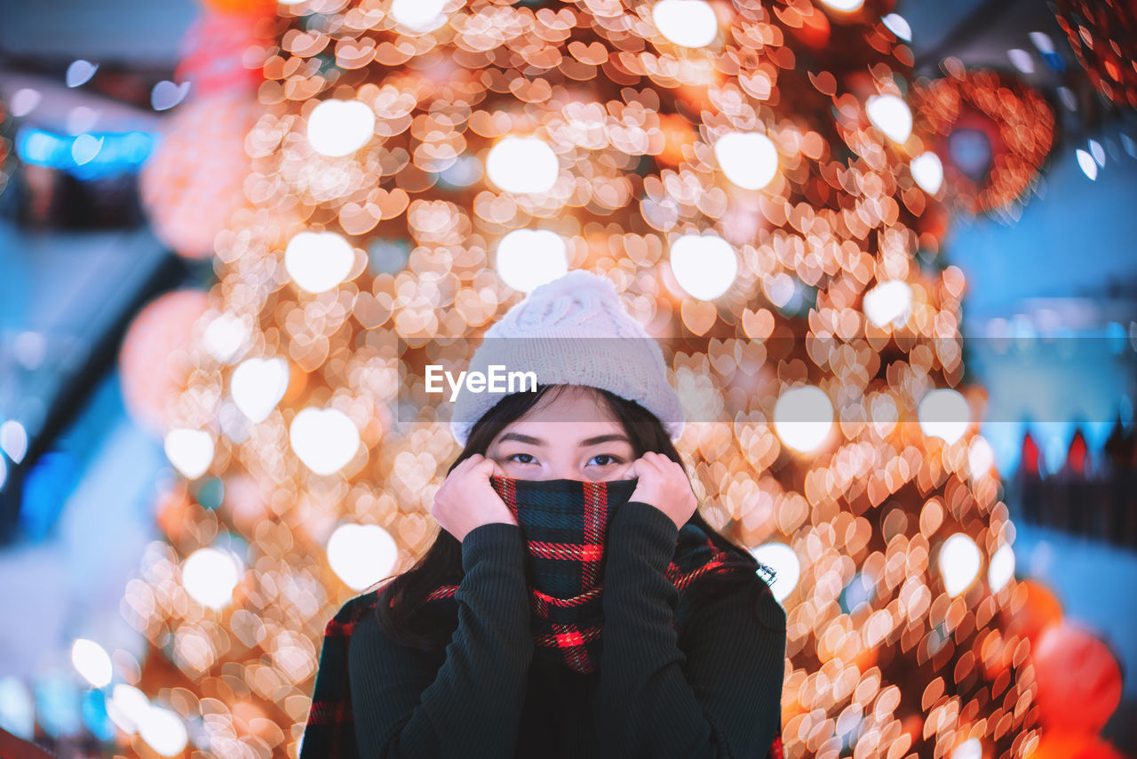 Portrait of woman in illuminated park during winter