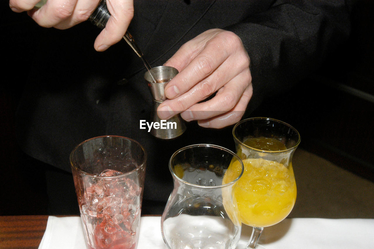 A barkeeper or bartender mixing drinks together in a bar