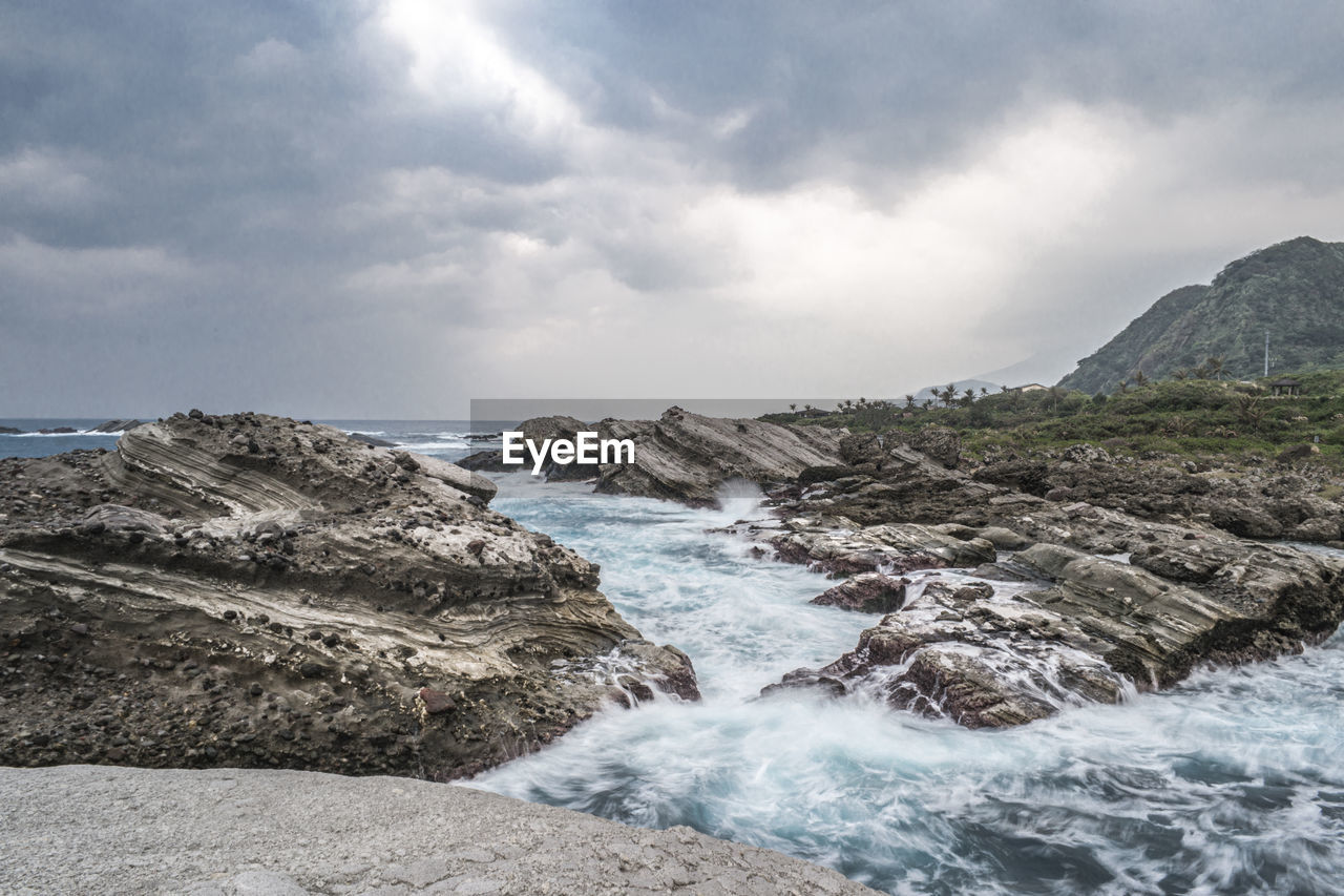 SCENIC VIEW OF ROCKS ON SEA AGAINST SKY