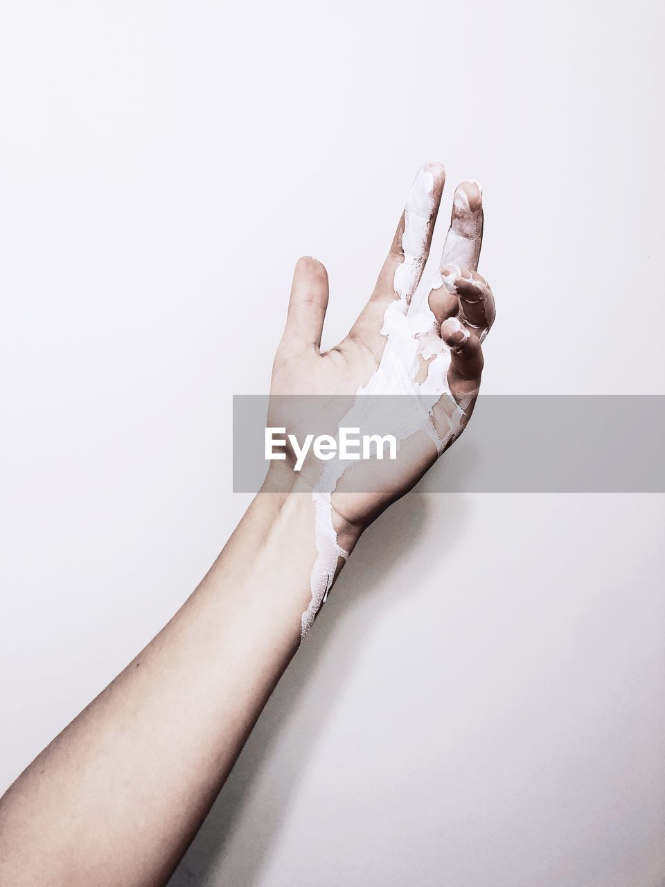 CLOSE-UP OF HUMAN HAND HOLDING WHITE BACKGROUND