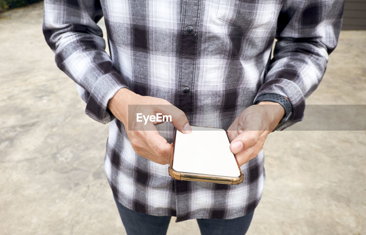 Young man stand and using mobile smart phone.