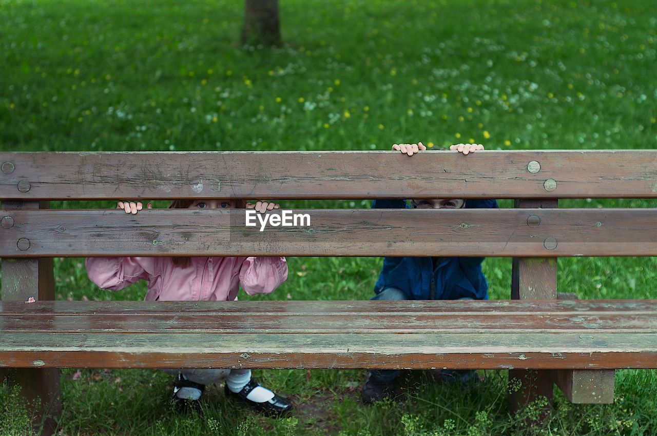 Children in park behind bench 