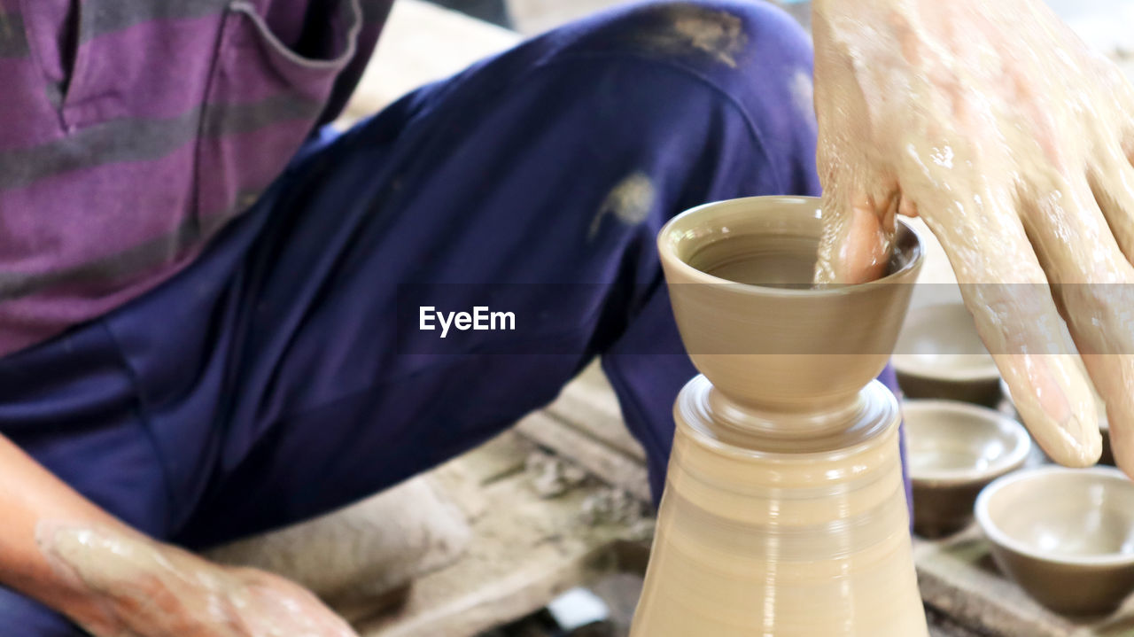 Midsection of potter making clay product