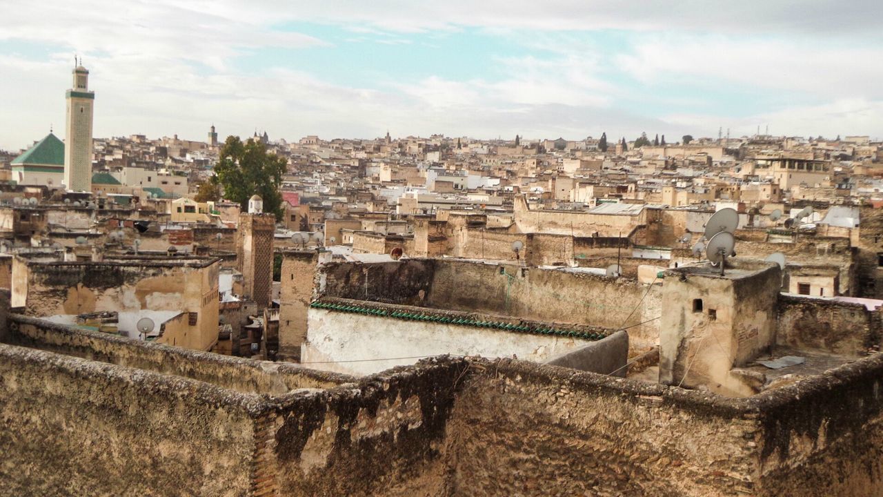 View of cityscape against cloudy sky