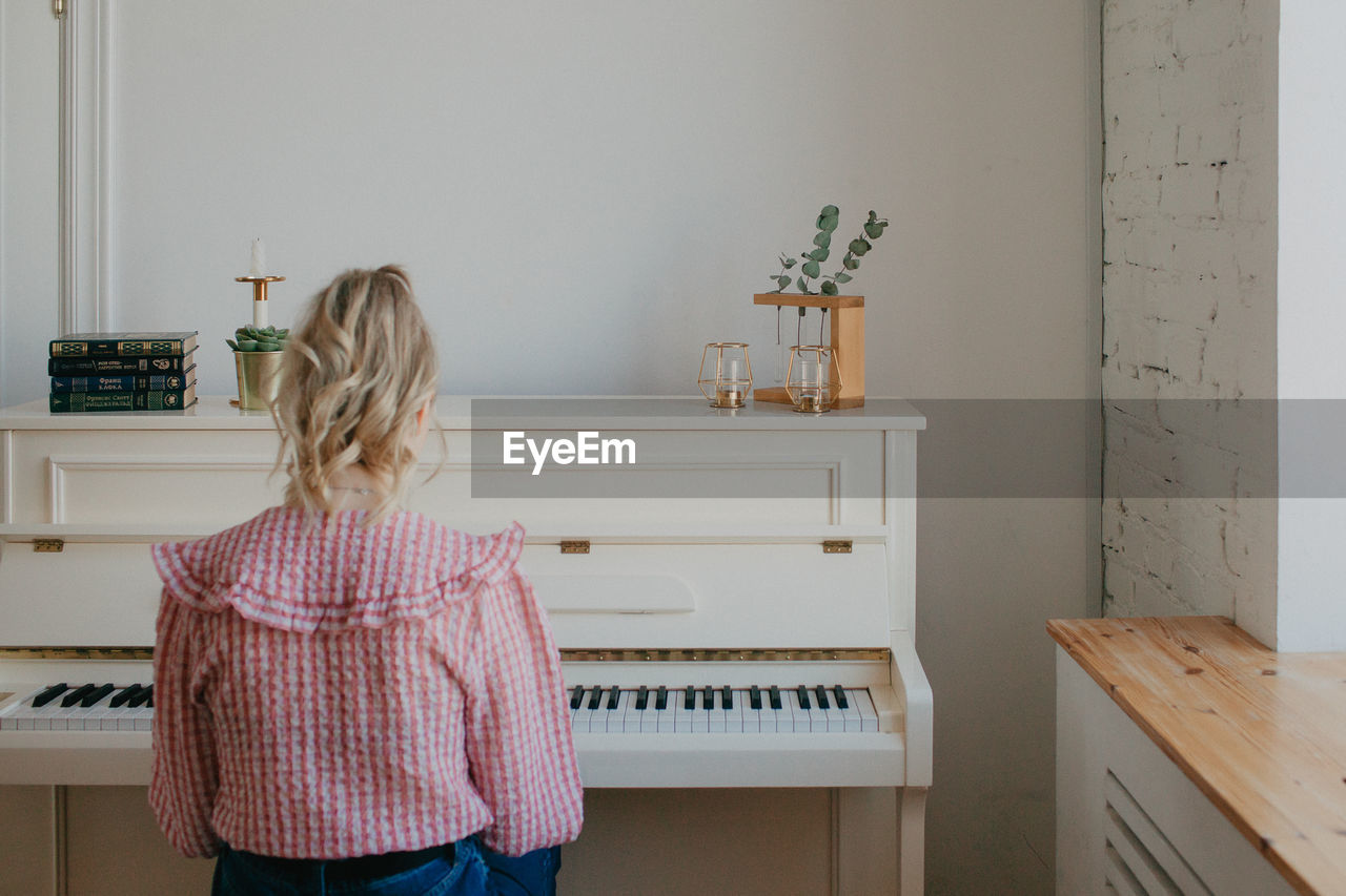 Young beautiful woman playing the piano. high quality photo