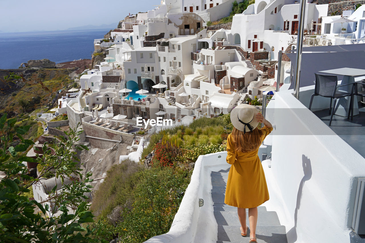 Holidays in santorini. young beautiful girl walking in oia village on santorini island, greece.