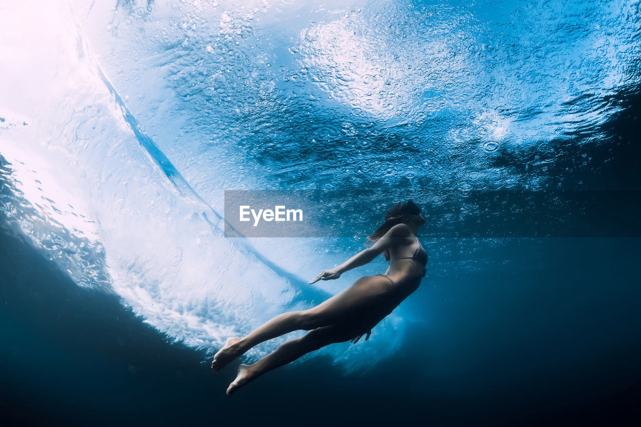 low section of man swimming in sea