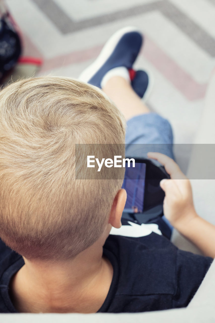 High angle view of boy playing video game at home