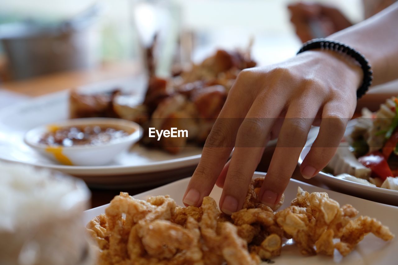 Close-up of woman preparing food in plate do not use hand to handle food directly during covid 19