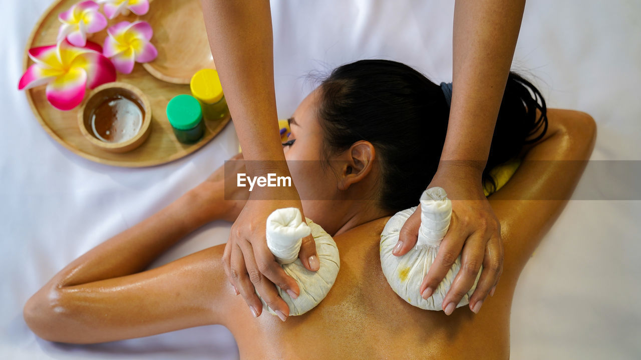 Beautiful asian woman laying her body to relax in an oil spa massage  salon. woman relaxing in spa.