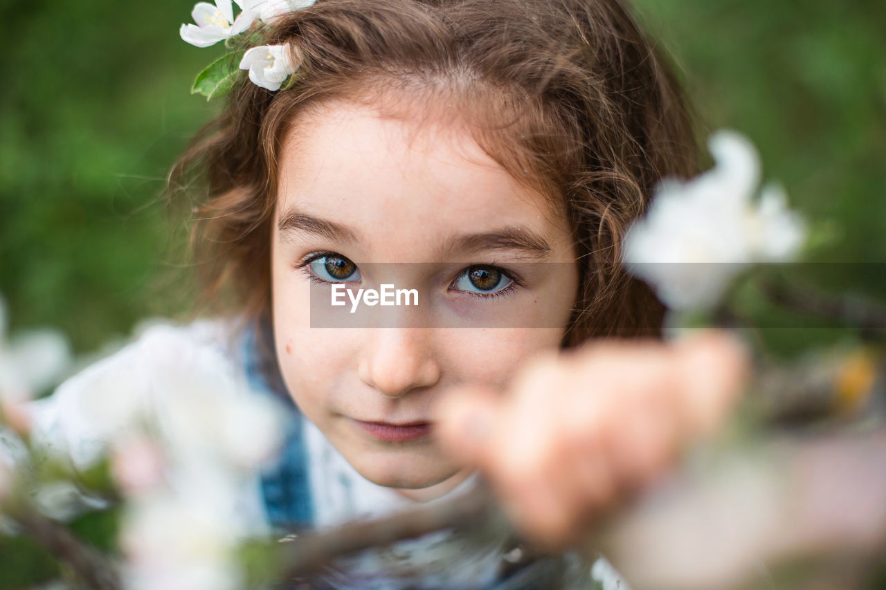 portrait, childhood, child, portrait photography, one person, flower, headshot, female, women, plant, looking at camera, selective focus, nature, toddler, emotion, innocence, cute, skin, person, close-up, smiling, eye, human face, happiness, hairstyle, brown hair, human eye, baby, flowering plant, front view, outdoors, summer, day, brown eyes, lifestyles, fun, positive emotion, bride, blue eyes, spring, front or back yard, beauty in nature, looking, casual clothing