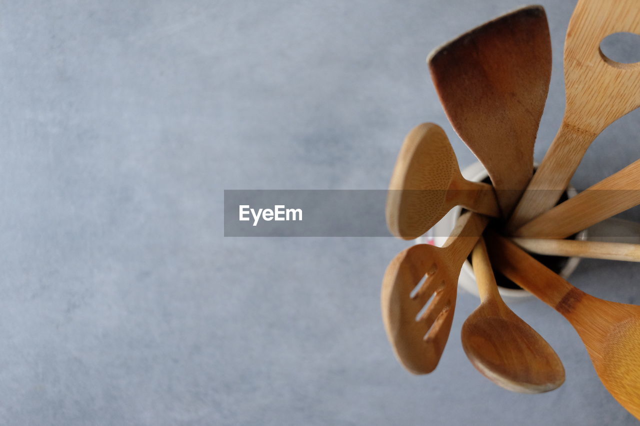 Directly above shot of wooden spoons in container on table