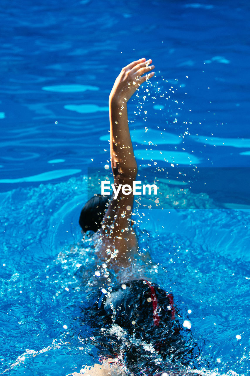 High angle view of teenage boy swimming in pool