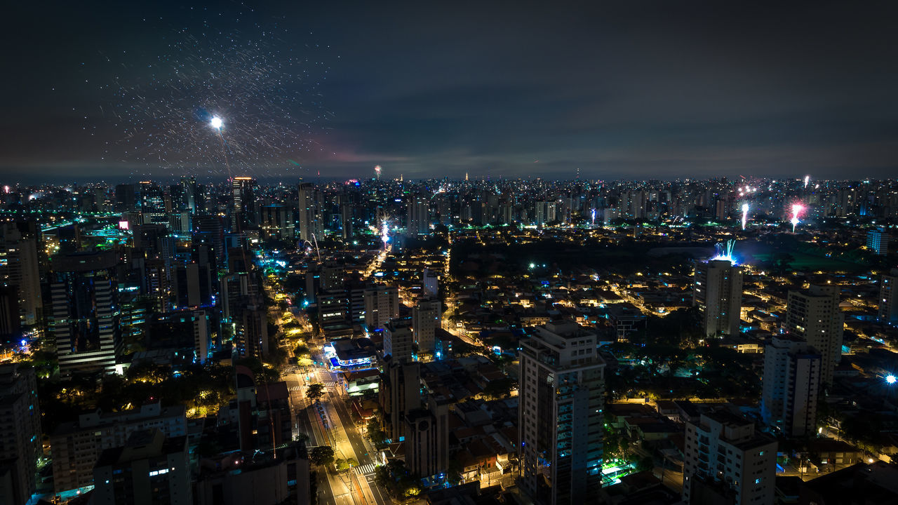 Aerial view of illuminated cityscape against sky at night