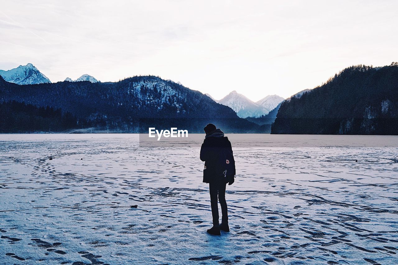 Full length of man on frozen lake against sky