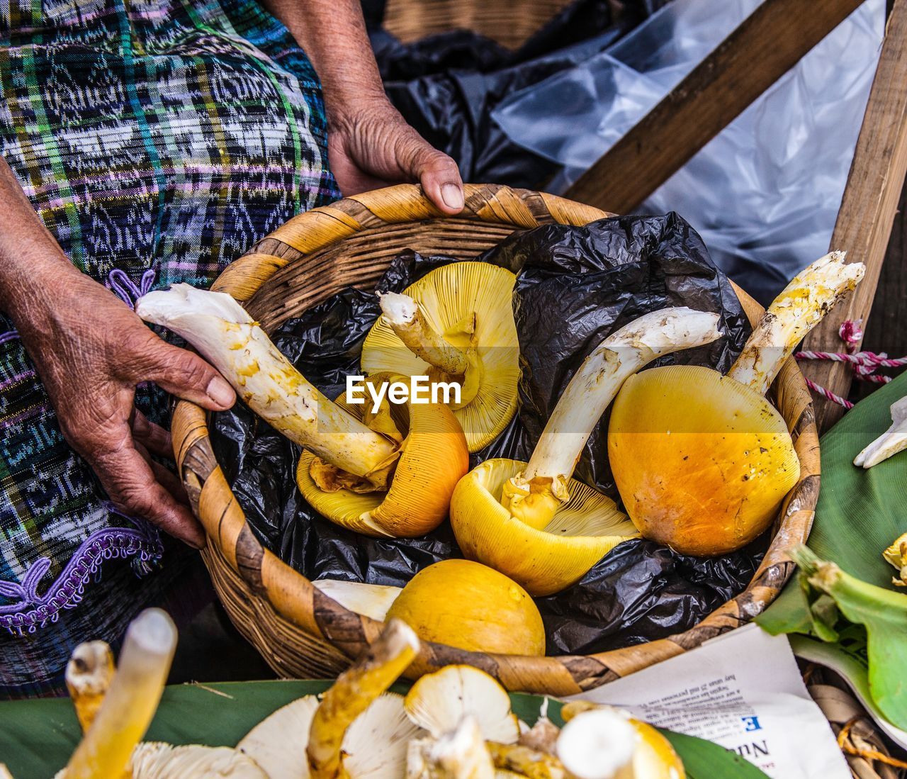 MIDSECTION OF MAN PREPARING FOOD FOR SALE AT MARKET