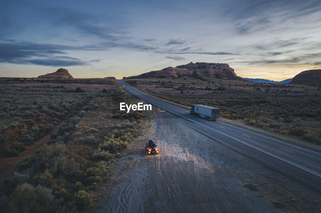 Lonely utah's road in the evening with a pulled over car