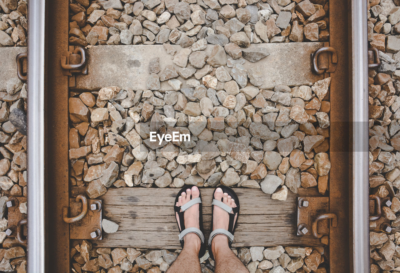 A man standing on the straight railroad or train tracks, the concept of journey travel, adventure 