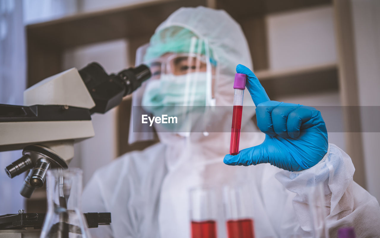 Close-up of doctor examining over microscope