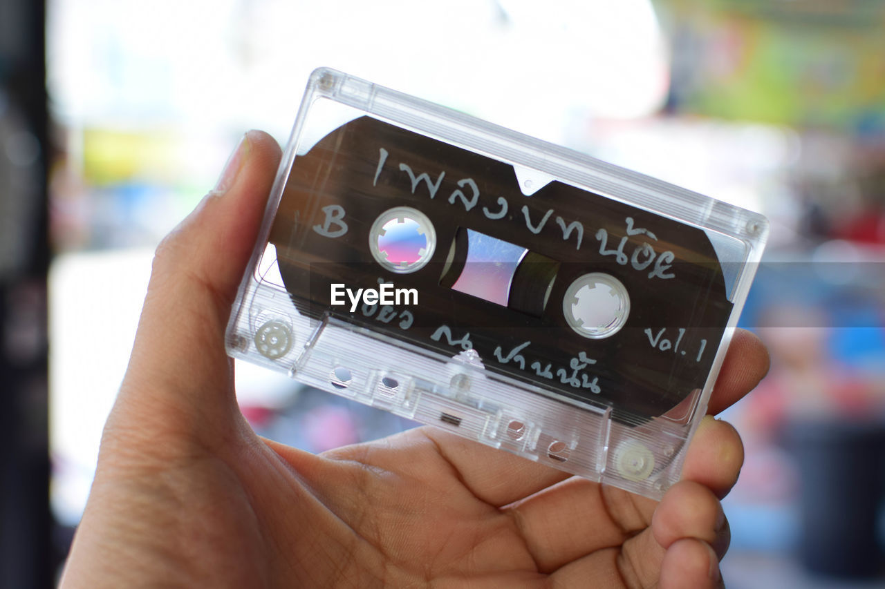 Close-up of person hand holding audio cassette