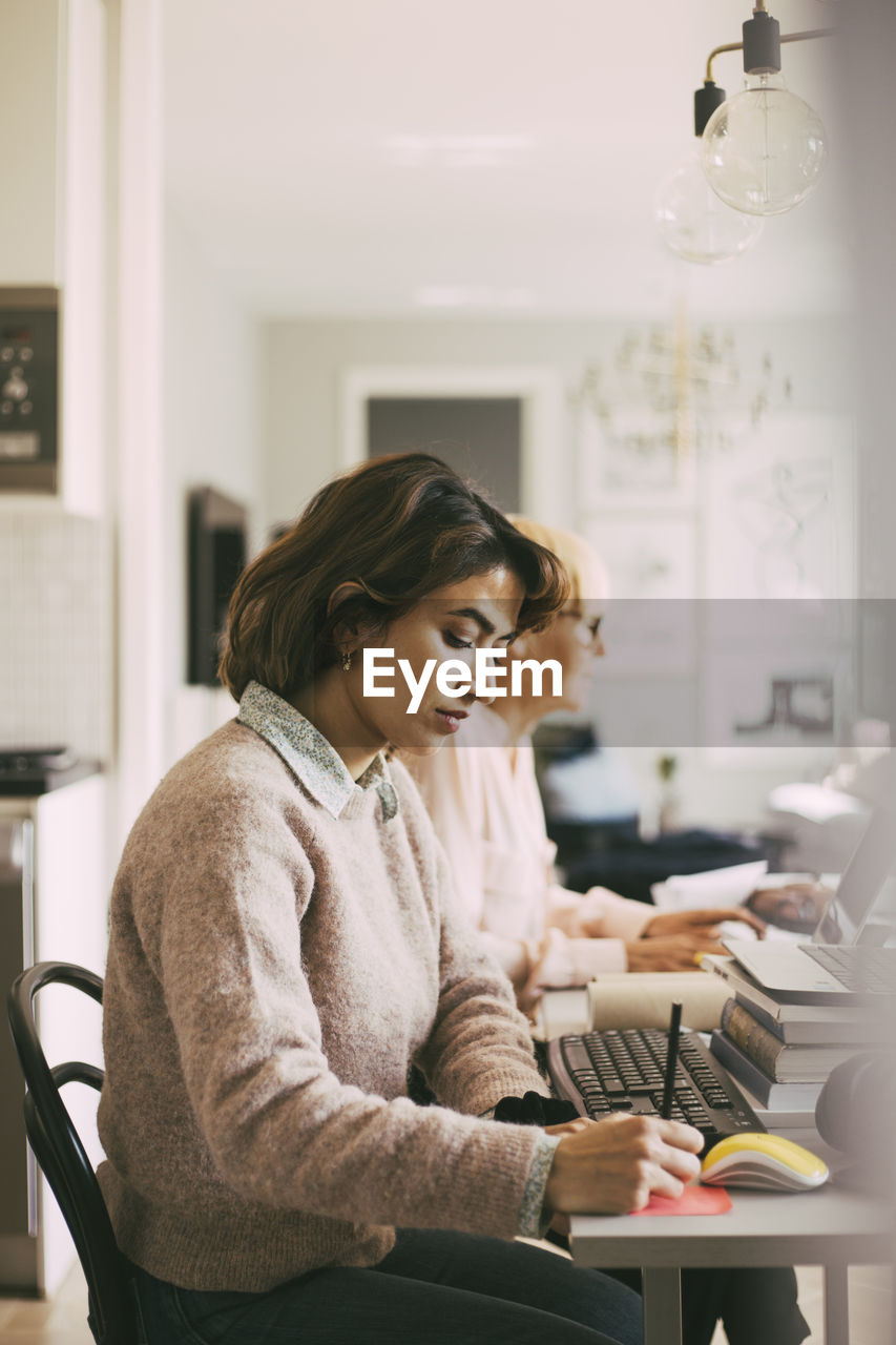 Two women working in living room at home