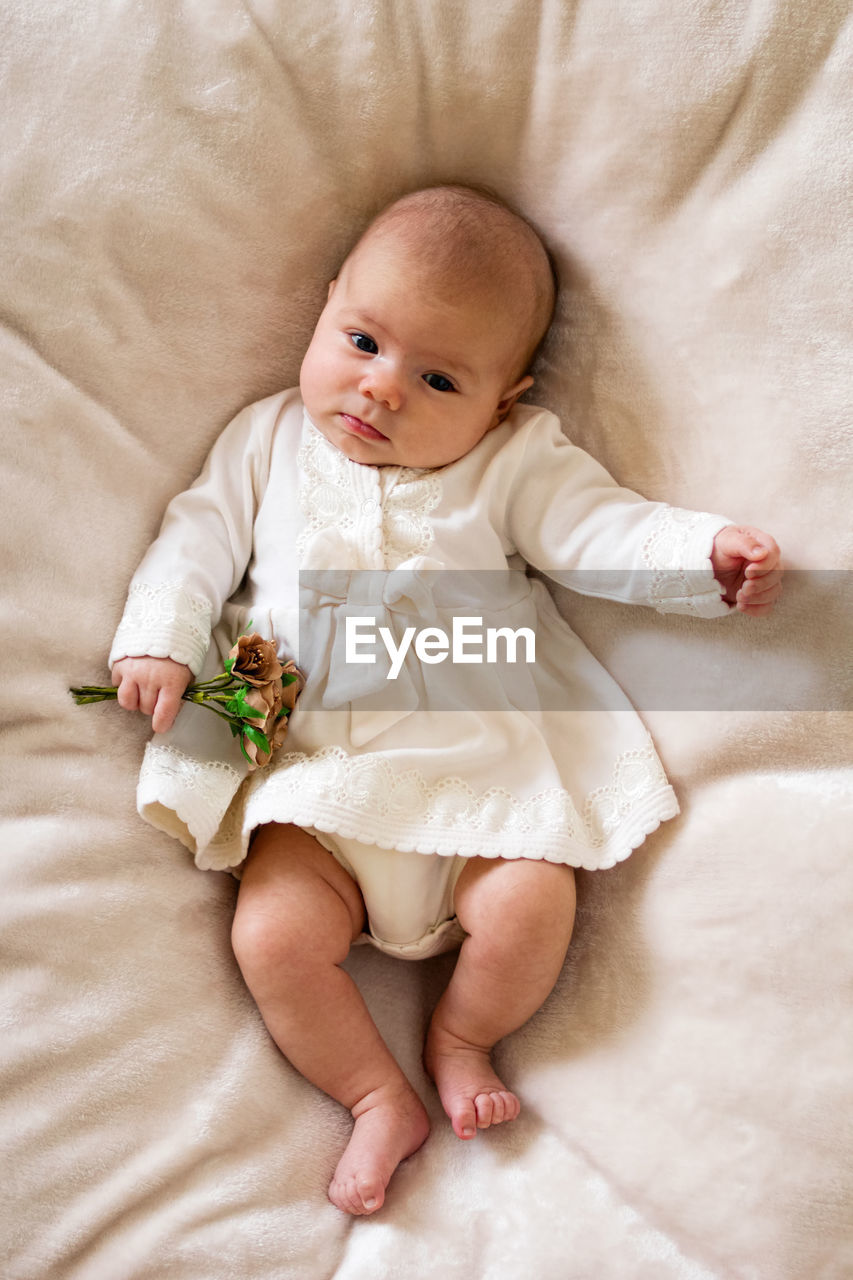 High angle view of baby lying on bed