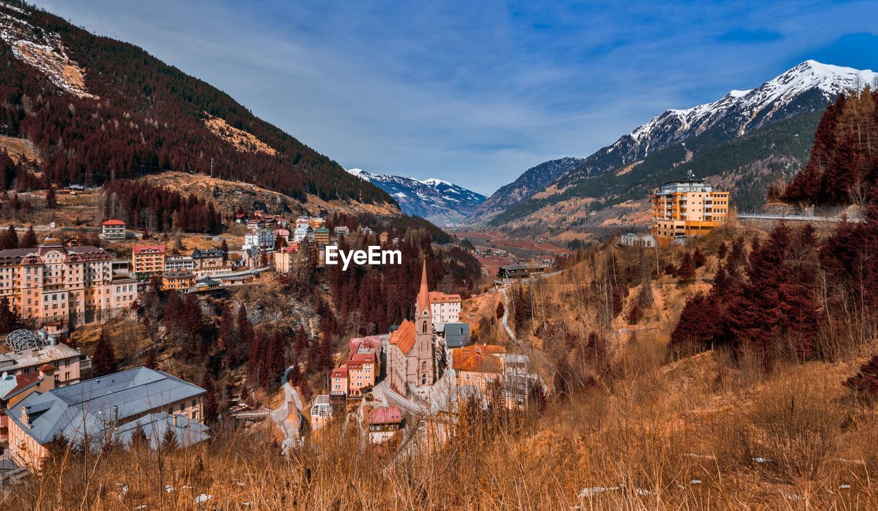 Buildings and mountains against blue sky