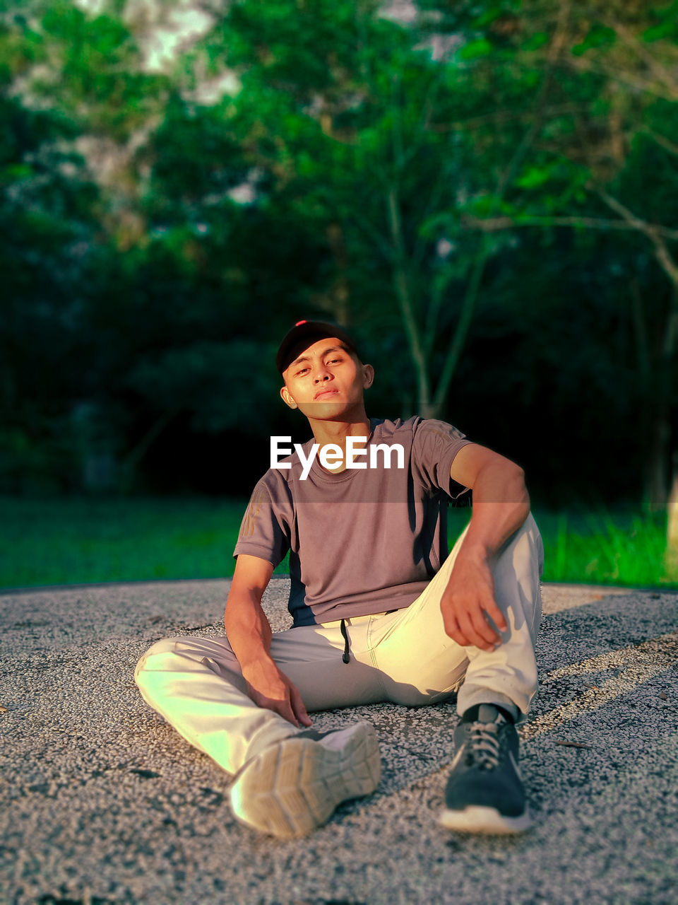 Portrait of young man sitting on road