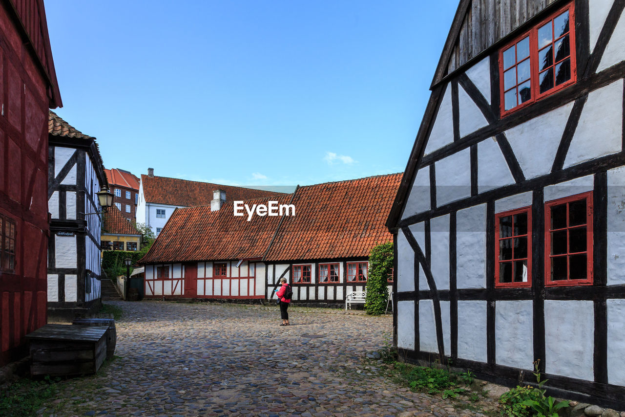 Houses by street against sky