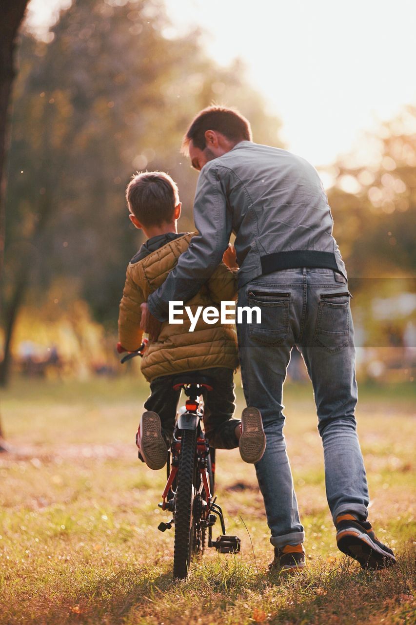 Father and son with bicycle in park