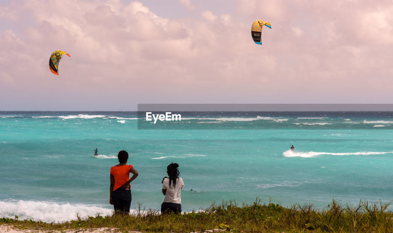 PEOPLE PARAGLIDING IN SEA