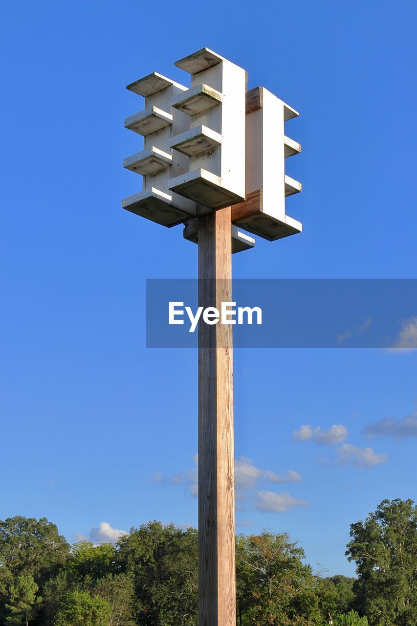 LOW ANGLE VIEW OF BIRDHOUSE AGAINST SKY