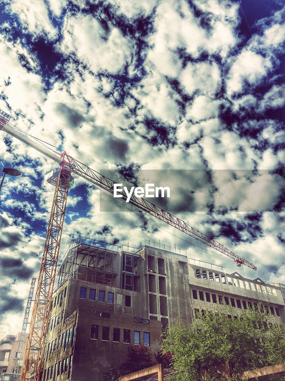 LOW ANGLE VIEW OF BUILT STRUCTURES AGAINST CLOUDY SKY