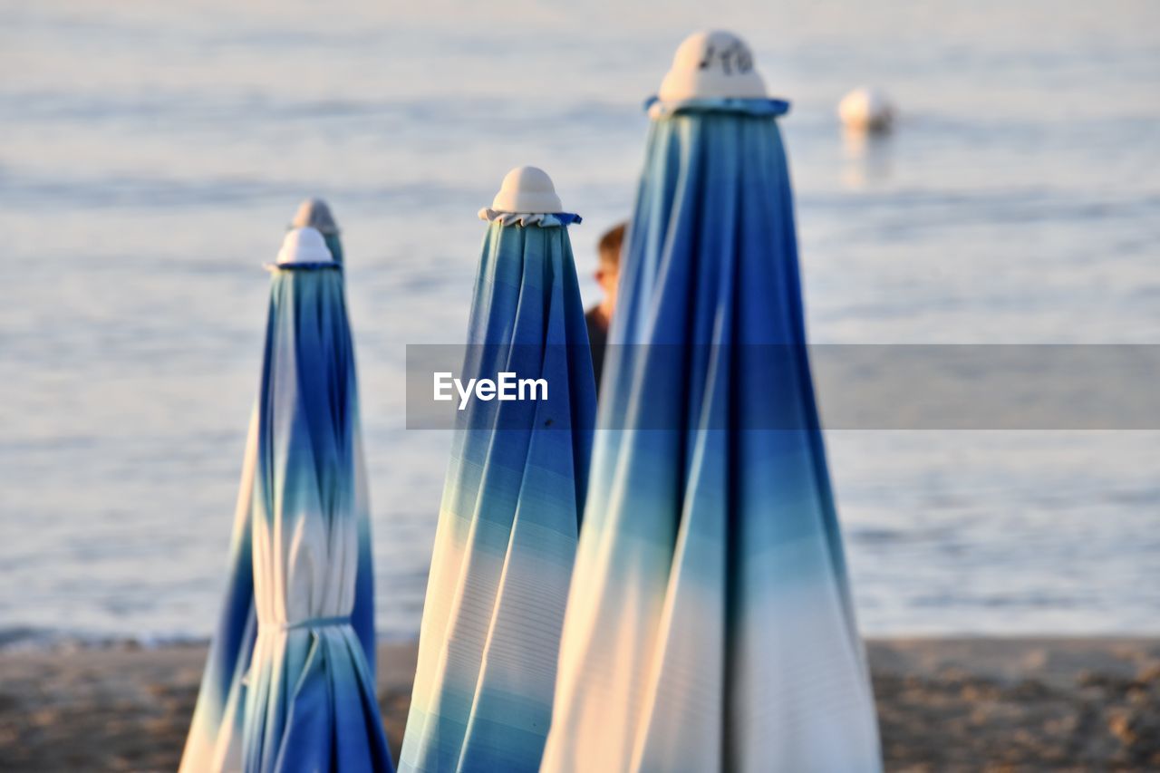 CLOSE-UP OF DECK CHAIRS ON BEACH AGAINST SEA