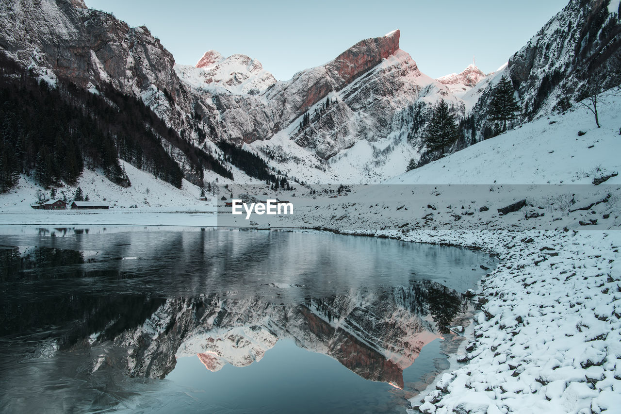 Scenic view of lake and snowcapped mountains during winter