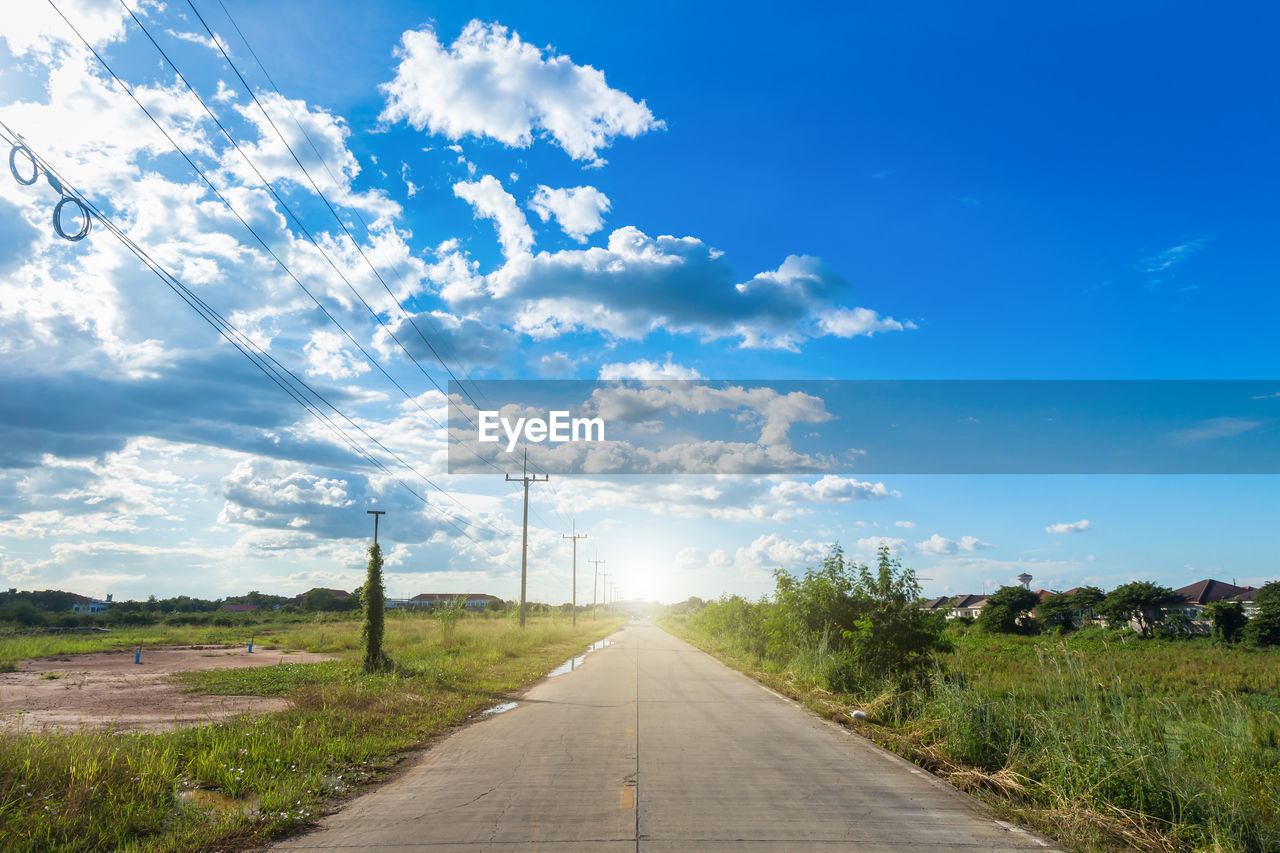 Road amidst field against sky